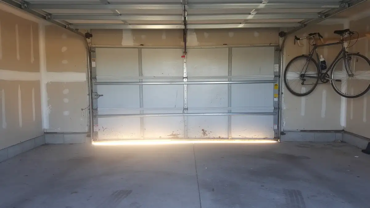 The garage door is closed, with a bicycle hanging on the right wall.